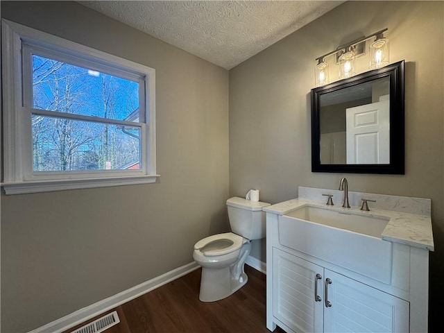 bathroom with vanity, hardwood / wood-style flooring, toilet, and a textured ceiling