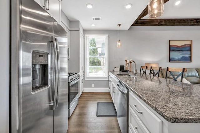 kitchen with a sink, dark wood-style floors, visible vents, white cabinets, and appliances with stainless steel finishes