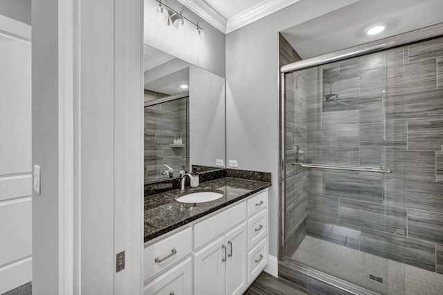 bathroom with vanity, ornamental molding, and a shower stall
