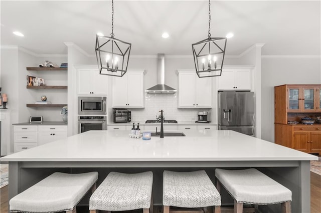 3 Hundley Ln, Roswell, GA 30076 - kitchen featuring wall chimney range hood, appliances with stainless steel finishes, a chandelier, a center island with sink, and ornamental molding