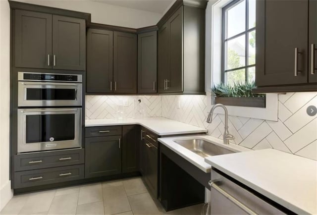 3 Hundley Ln, Roswell, GA 30076 - kitchen featuring appliances with stainless steel finishes, light countertops, light tile patterned flooring, tasteful backsplash, and a sink