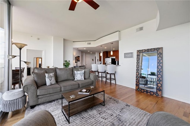 living room with ceiling fan and light wood-type flooring