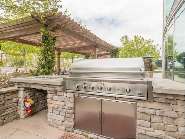 view of patio featuring exterior kitchen, a grill, and a pergola