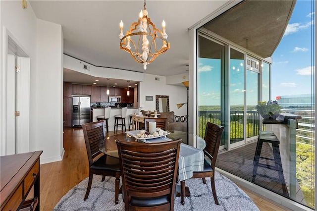 dining space with a notable chandelier and hardwood / wood-style floors