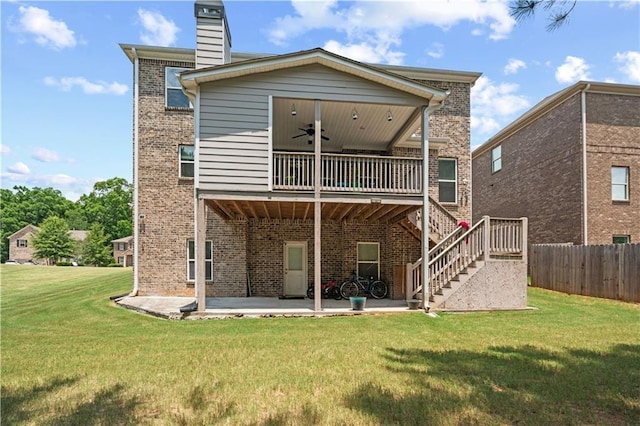 rear view of house featuring a patio, brick siding, a ceiling fan, a lawn, and stairway