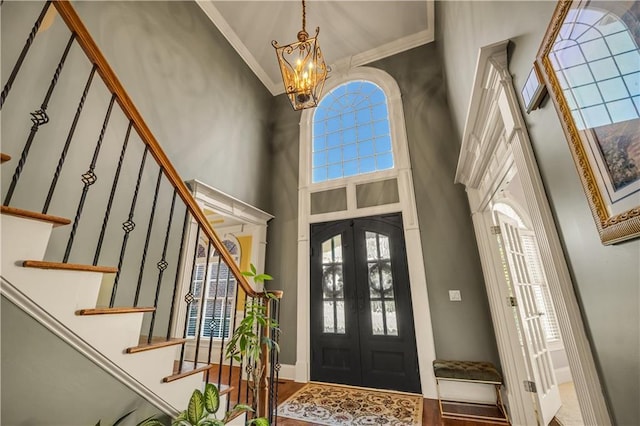 3855 Greenside Ct, Dacula, GA 30019 - entryway featuring ornamental molding, a towering ceiling, stairway, french doors, and a notable chandelier