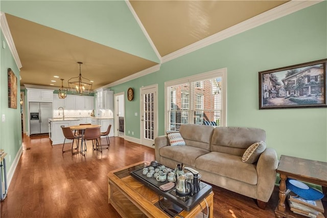 3855 Greenside Ct, Dacula, GA 30019 - living room with vaulted ceiling, baseboards, an inviting chandelier, ornamental molding, and dark wood-type flooring