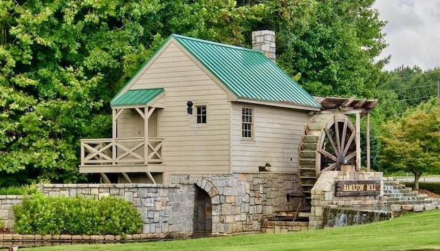 3855 Greenside Ct, Dacula, GA 30019 - back of property with stairs, stone siding, a chimney, a standing seam roof, and metal roof