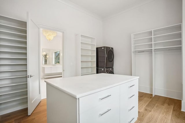 walk in closet featuring light hardwood / wood-style floors and stacked washer / drying machine