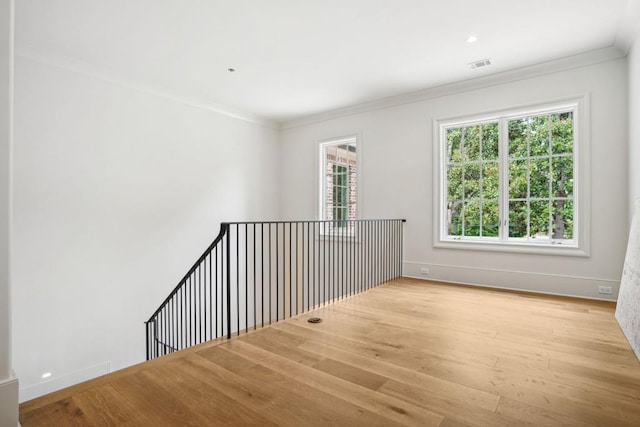 spare room featuring light hardwood / wood-style flooring and ornamental molding