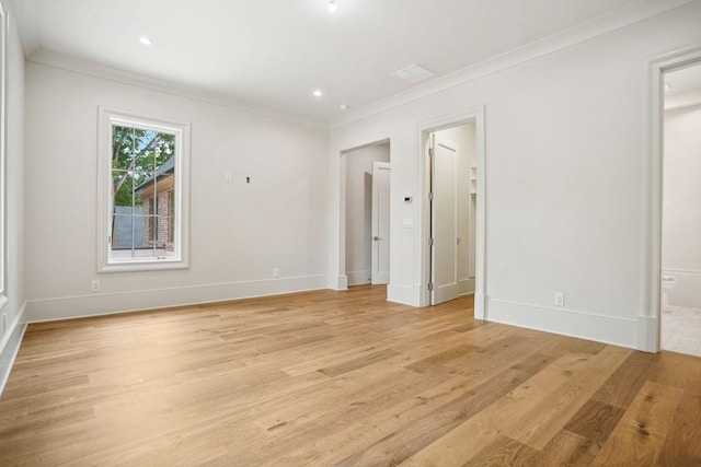 empty room with light wood-type flooring and ornamental molding