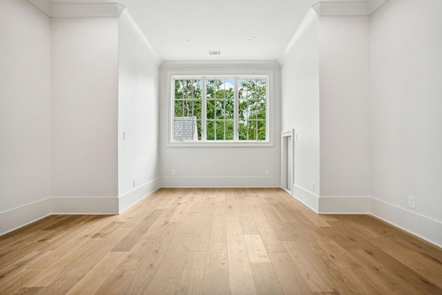 spare room with crown molding and light hardwood / wood-style flooring