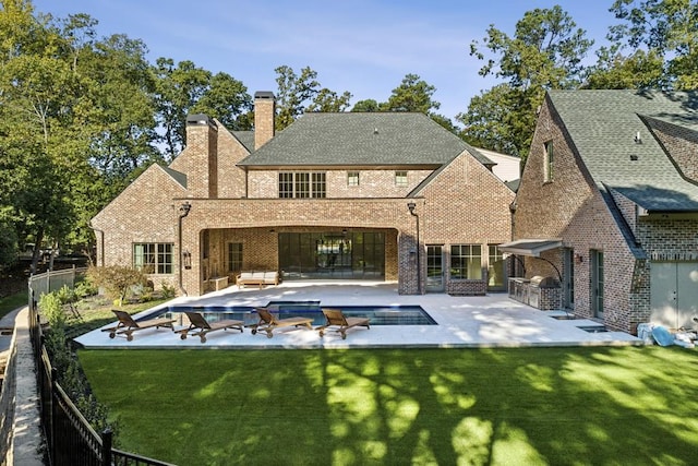 rear view of house with a lawn, an outdoor living space, area for grilling, and a patio area