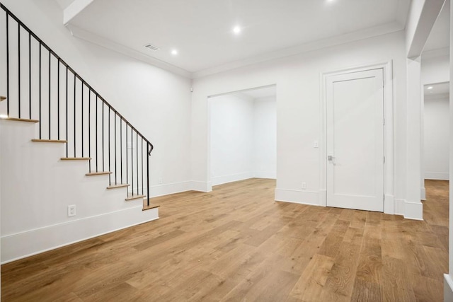 interior space with light wood-type flooring and ornamental molding