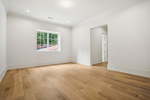 unfurnished room with ornamental molding and light wood-type flooring