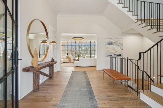 foyer entrance featuring crown molding and wood-type flooring