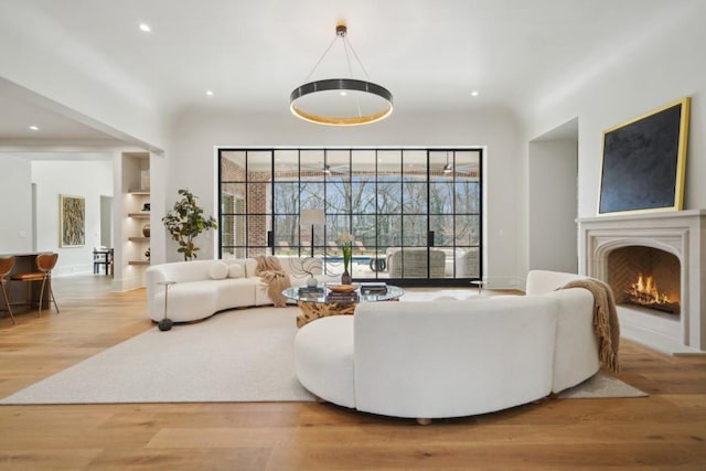 living room featuring built in features and light hardwood / wood-style floors