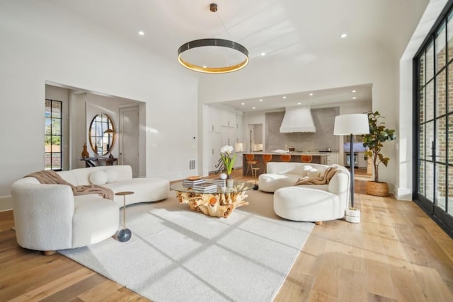 living room with light hardwood / wood-style floors and a high ceiling