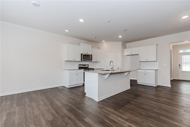 6706 Moondancer Ct, Flowery Branch, GA 30542 - kitchen with appliances with stainless steel finishes, ornamental molding, dark wood finished floors, tasteful backsplash, and white cabinetry