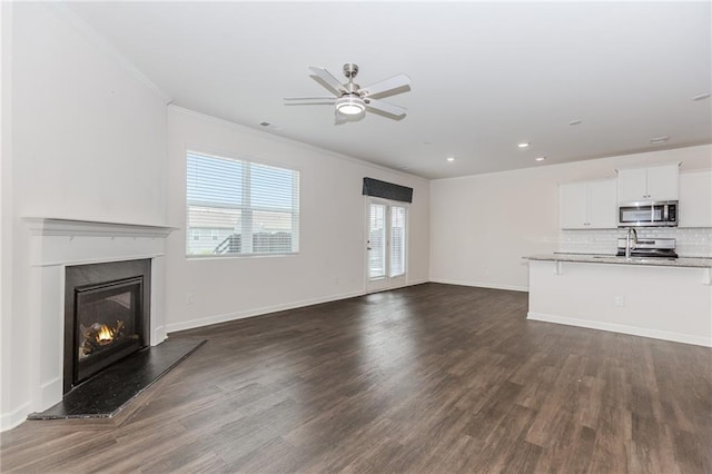 6706 Moondancer Ct, Flowery Branch, GA 30542 - unfurnished living room featuring dark wood finished floors, ornamental molding, ceiling fan, a glass covered fireplace, and recessed lighting