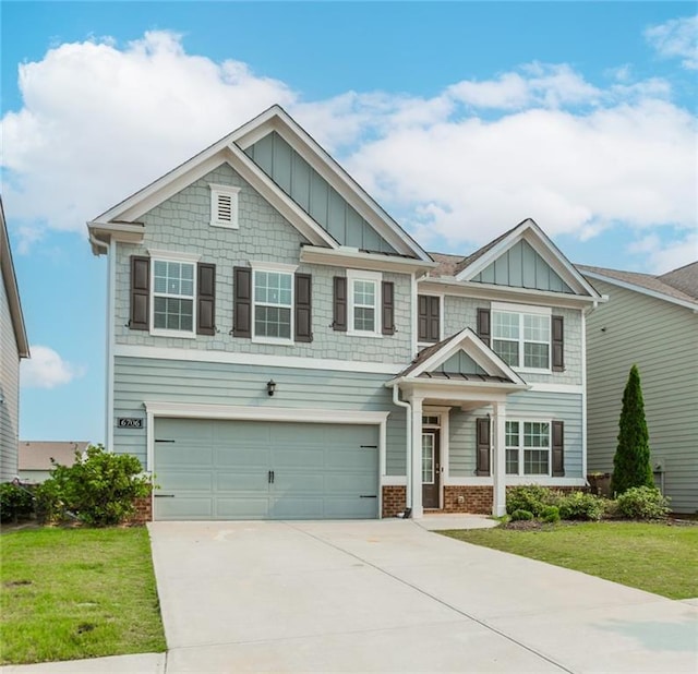 6706 Moondancer Ct, Flowery Branch, GA 30542 - craftsman inspired home with board and batten siding, driveway, a garage, a front lawn, and brick siding