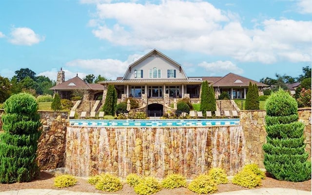 6706 Moondancer Ct, Flowery Branch, GA 30542 - rear view of house featuring a gambrel roof and an outdoor pool