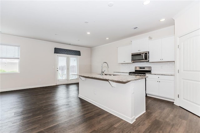 6706 Moondancer Ct, Flowery Branch, GA 30542 - kitchen with stainless steel appliances, ornamental molding, an island with sink, decorative backsplash, and white cabinets