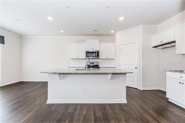 6706 Moondancer Ct, Flowery Branch, GA 30542 - kitchen with stainless steel appliances, light stone counters, dark wood finished floors, white cabinets, and crown molding