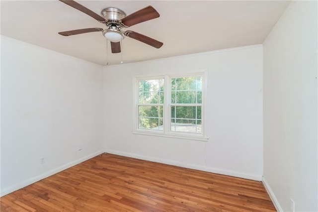 unfurnished room featuring a ceiling fan, wood finished floors, baseboards, and ornamental molding