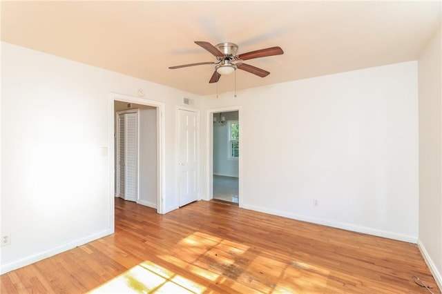 unfurnished room featuring light wood-style flooring, baseboards, and ceiling fan