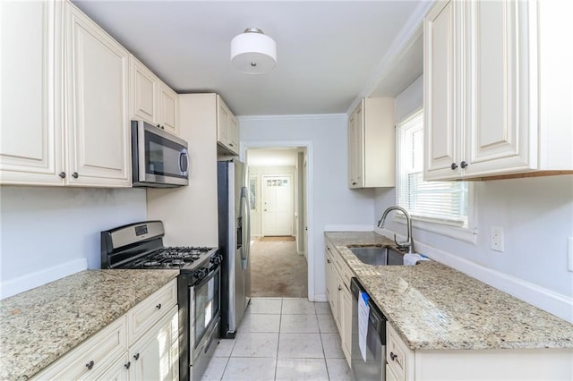 kitchen with baseboards, light stone countertops, light tile patterned floors, stainless steel appliances, and a sink