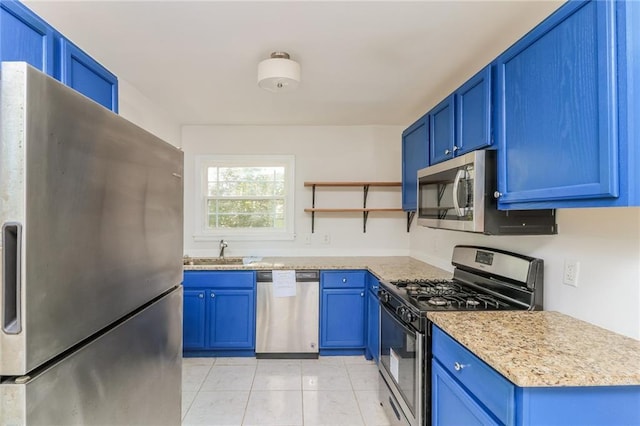 kitchen with blue cabinetry, open shelves, stainless steel appliances, and a sink