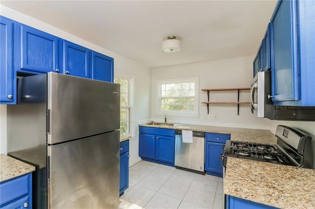 kitchen with a sink, open shelves, blue cabinetry, and stainless steel appliances