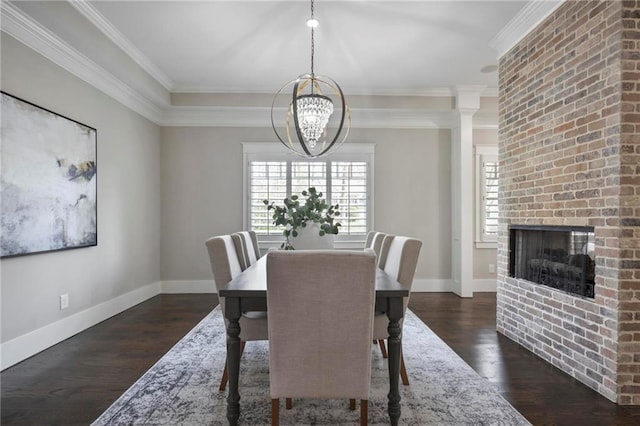 dining space with ornamental molding, dark wood-style flooring, a fireplace, and baseboards