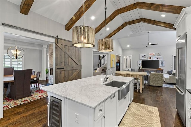 kitchen with a barn door, beverage cooler, a sink, open floor plan, and dark wood-style floors