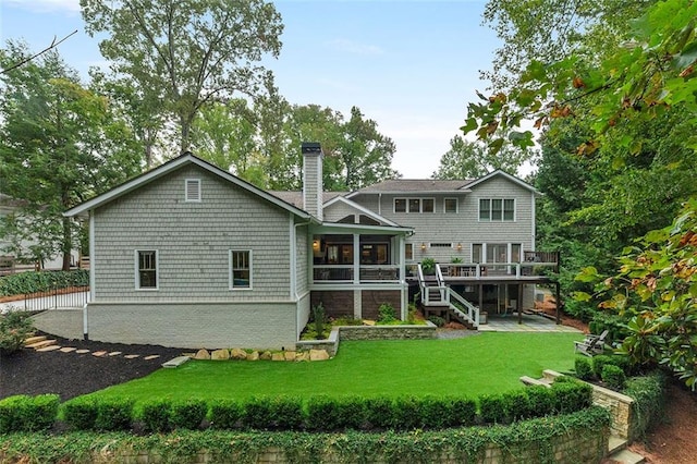 rear view of house featuring a yard, a chimney, stairway, a patio area, and a deck