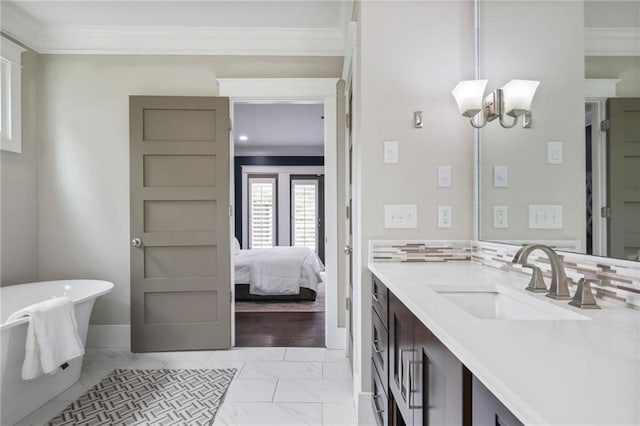 bathroom featuring marble finish floor, crown molding, a soaking tub, vanity, and a chandelier