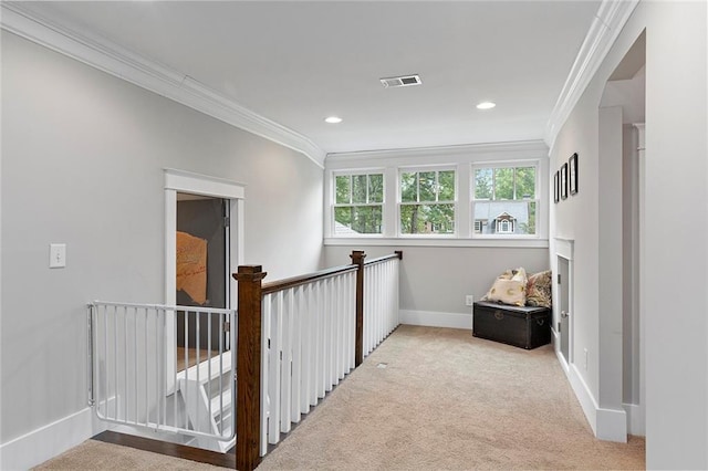 corridor with baseboards, visible vents, crown molding, and carpet flooring