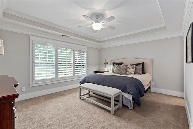 carpeted bedroom with a tray ceiling, visible vents, ornamental molding, ceiling fan, and baseboards