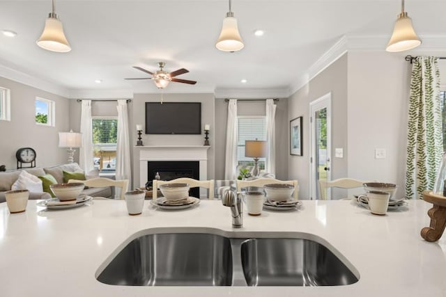 kitchen with open floor plan, light countertops, a sink, and decorative light fixtures