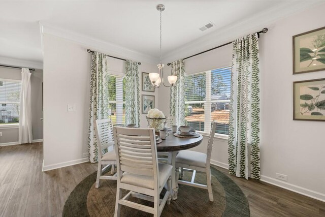 dining space featuring dark wood-style flooring, visible vents, plenty of natural light, and an inviting chandelier