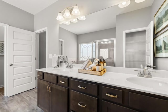 bathroom with double vanity, a sink, and wood finished floors