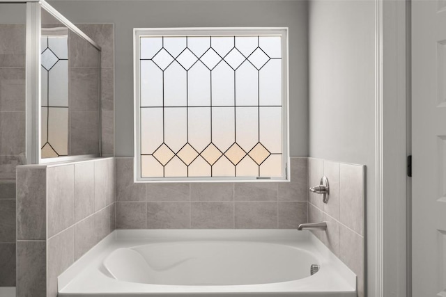 bathroom featuring a healthy amount of sunlight, a stall shower, and a bath