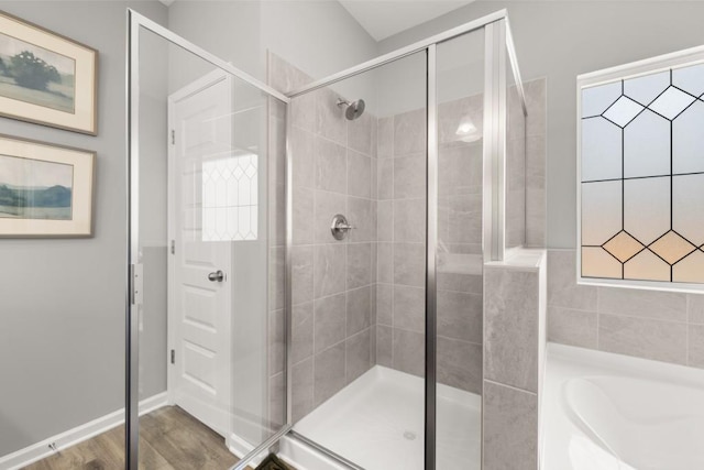 full bath featuring a garden tub, wood finished floors, and a shower stall