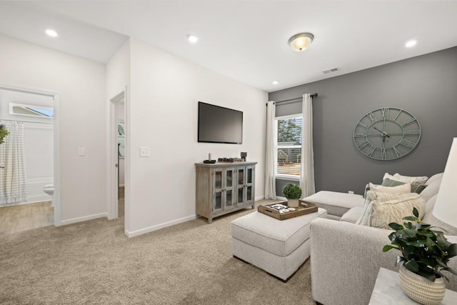 living room with recessed lighting, light carpet, visible vents, and baseboards