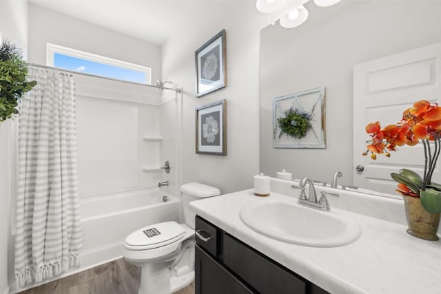 bathroom featuring toilet, wood finished floors, shower / tub combo with curtain, and vanity