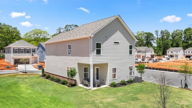 rear view of house with a lawn, a residential view, and central air condition unit