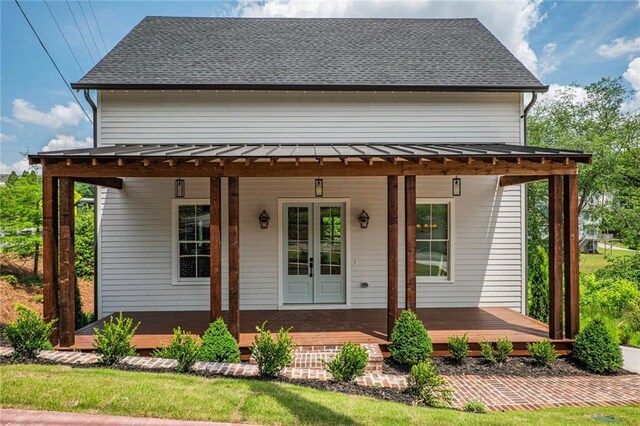 back of house with a standing seam roof, french doors, and metal roof