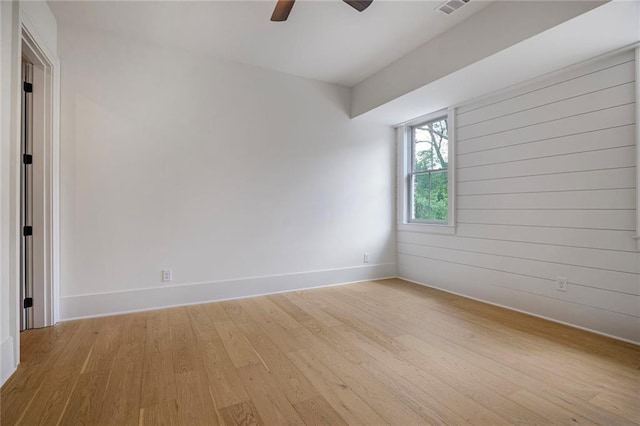 unfurnished room with baseboards, light wood-type flooring, and ceiling fan