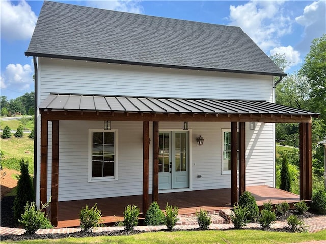 rear view of property featuring a standing seam roof, metal roof, and a porch